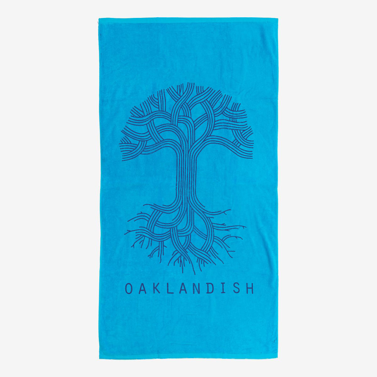 The Classic Logo Beach Towel from Oaklandish features a bright blue, oversized plush design with a stylized drawing of a tree with intertwining branches and roots created with bold black lines. Below the tree, the text "OAKLANDISH" is printed in black capital letters. Crafted from cotton terry velour, this rectangular towel also boasts a plain background.