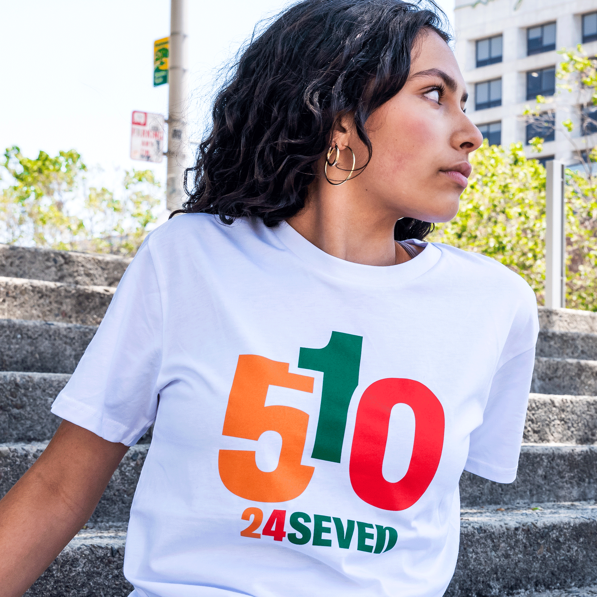 Close up view of Female model wearing white cotton t-shirt with 510 24 Seven graphic.