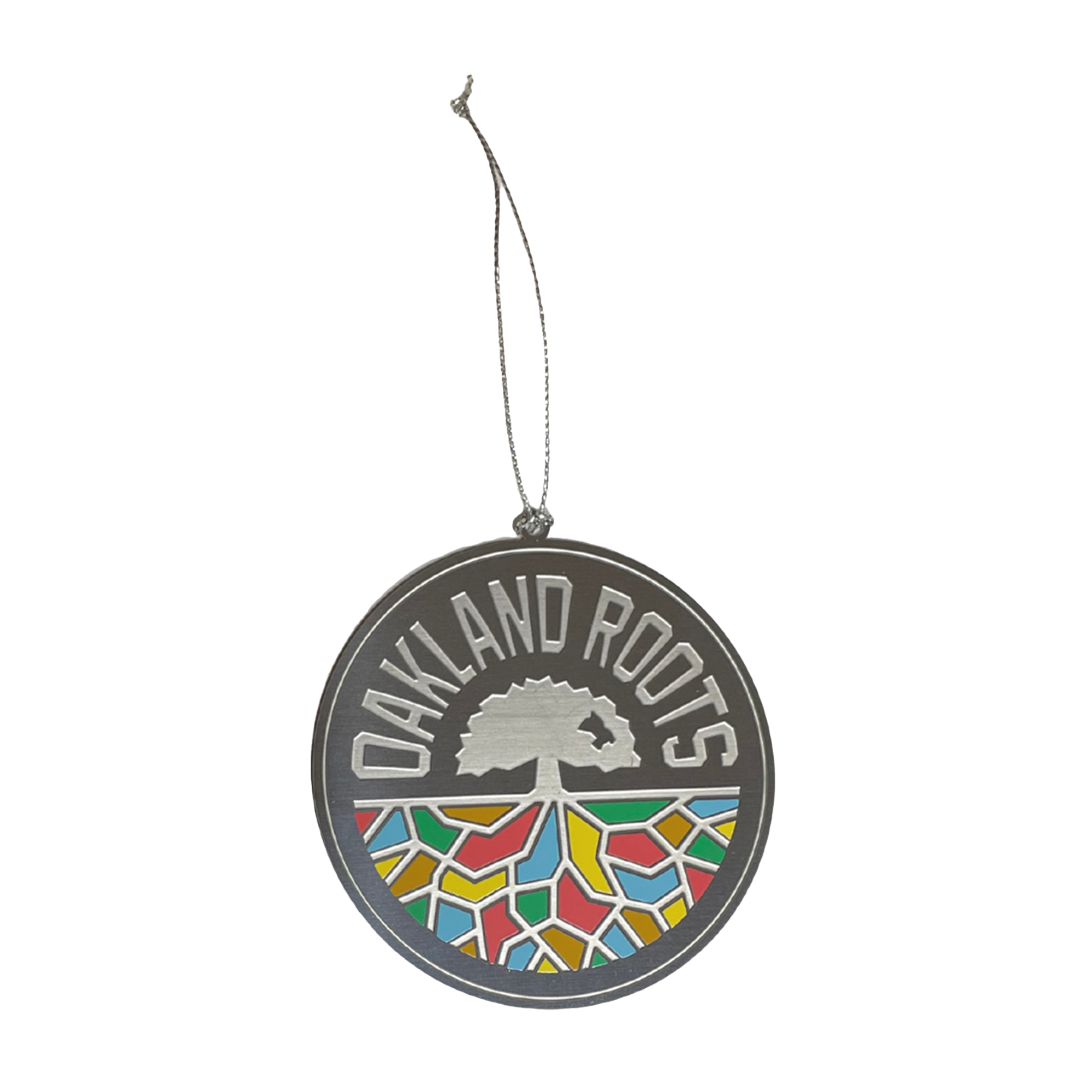 The Oakland Roots SC Crest Ornament by Oakland Roots SC features a circular pendant with "Oakland Roots" text above a stylized tree. Below the tree, colorful geometric shapes symbolize Homies Empowerment, and a thin string is attached at the top for hanging. The design is both modern and vibrant.