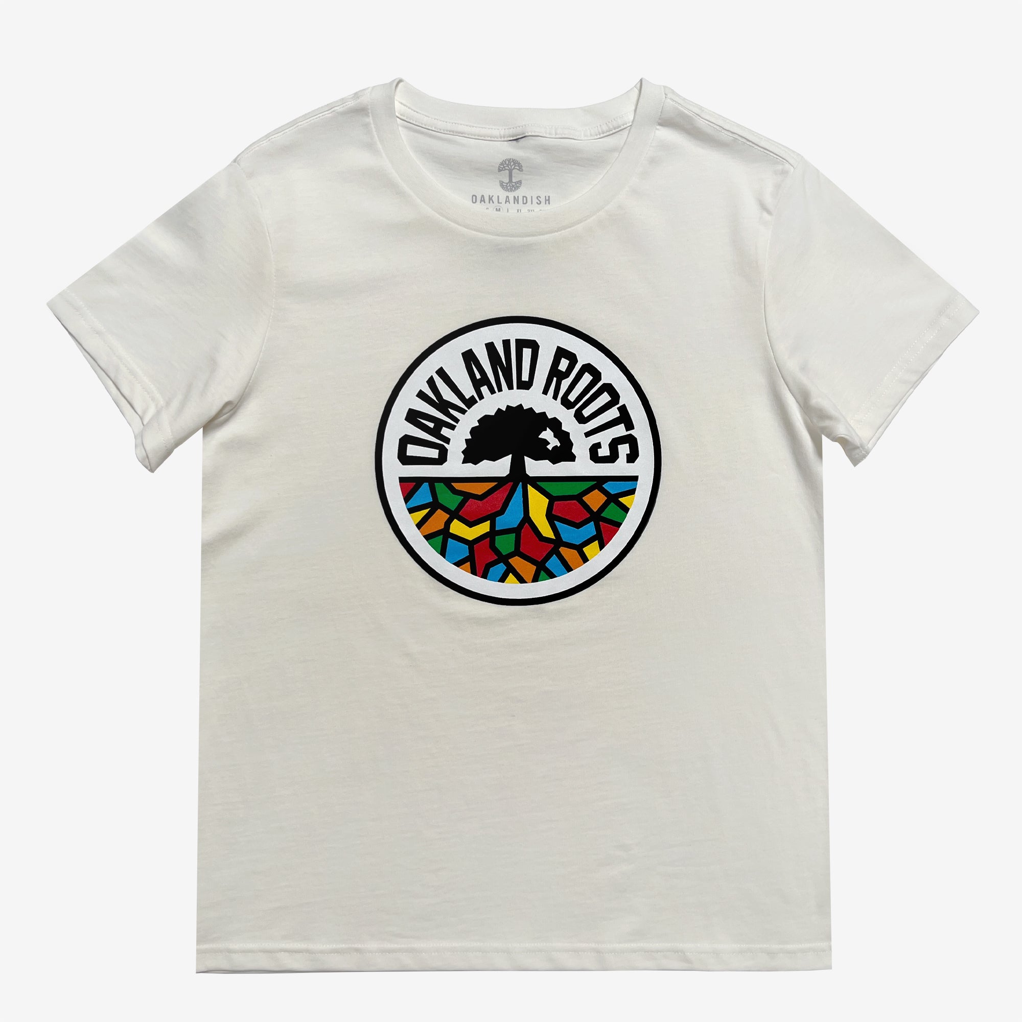 A Women's Oakland Roots SC Classic Tee in white, showcasing the "Oakland Roots" logo prominently centered on the front. The circular logo consists of a black tree silhouette with a colorful, geometric ground pattern in blue, red, green, and yellow beneath it. The words "OAKLAND ROOTS" are written in black around the top of the circle, representing this vibrant sports club from the Oakland Roots SC brand.