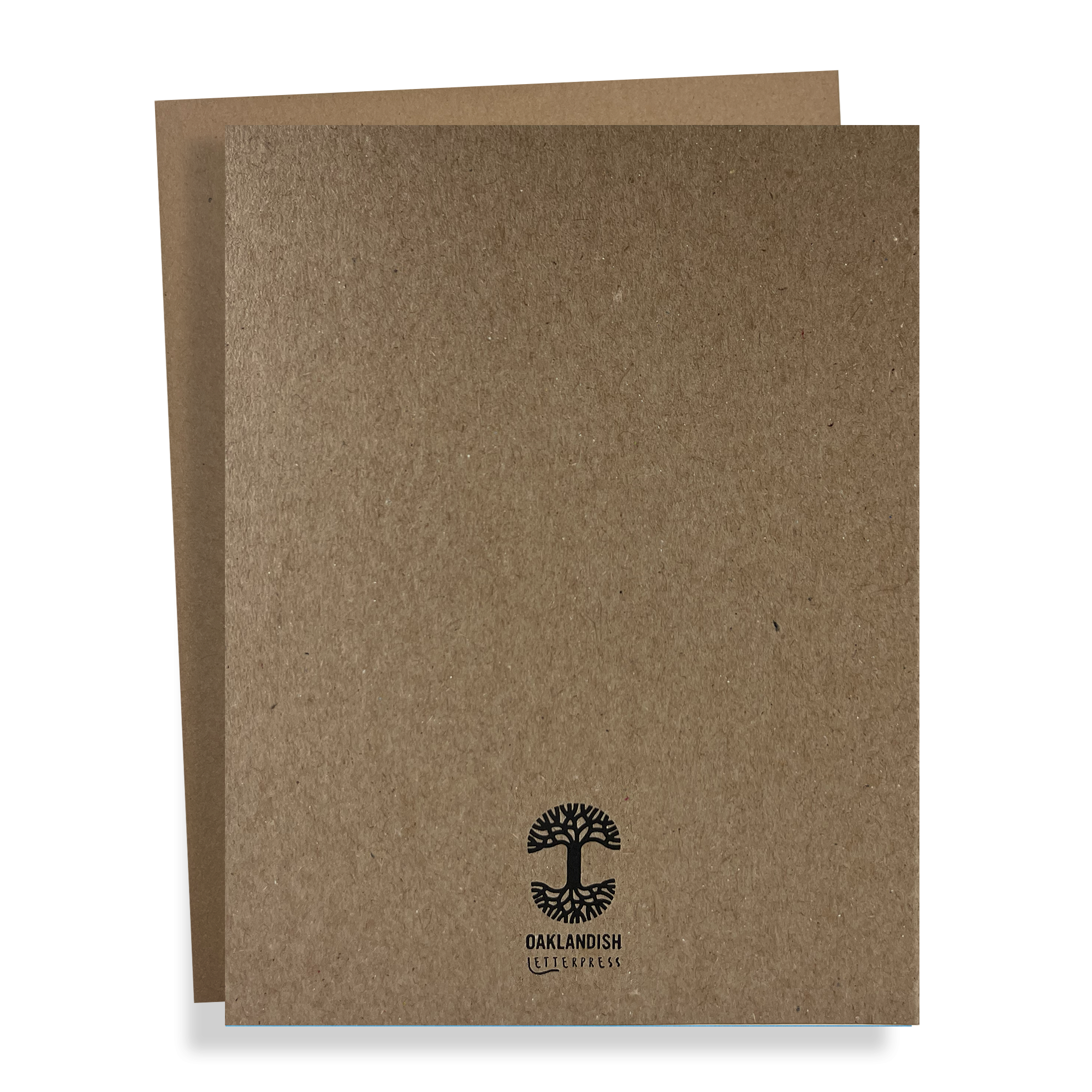 Two brown "Oaklandish Classic Logo Card" folders by Never Elsewhere are stacked, with the front one slightly shifted to the right to reveal the edge of the back folder. The front folder bears a black logo of a tree with roots, followed by the text "OAKLANDISH" and additional unreadable smaller text beneath it in metallic gold foil. The background is white.