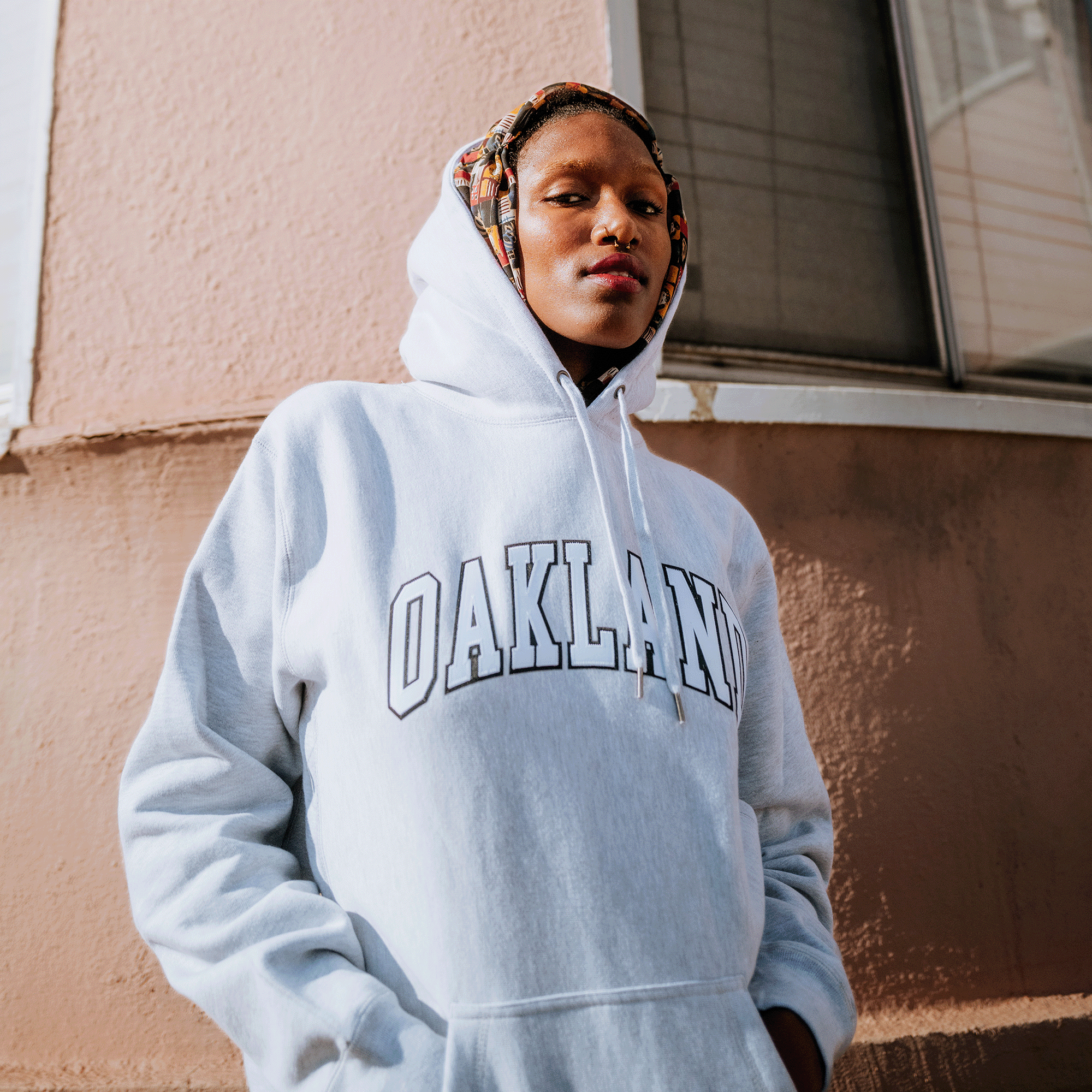 A woman in an Oaklandish Alma Mater Heavy Hoodie.