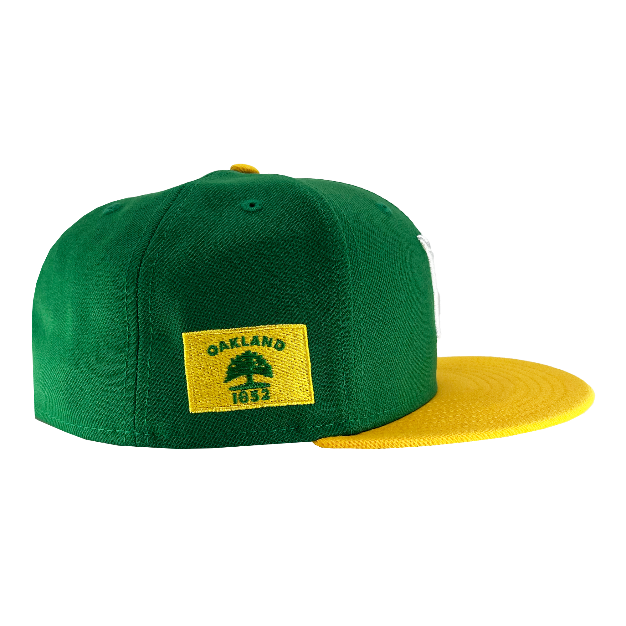 A green and yellow New Era Oakland Ballers 59Fifty Cap by Oakland Ballers is depicted. The back panel is green with a yellow rectangular patch that displays a green tree and the text "OAKLAND 1852," capturing the essence of Oakland sports team pride. The brim of the cap is yellow. The hat is presented on a white background, highlighting its side and back views.