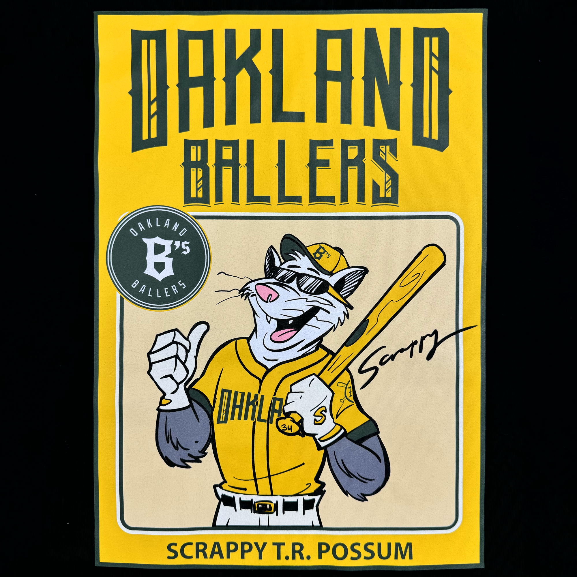 Scrappy T.R. Possum is featured on the Scrappy Rookie Card Tee by Oakland Ballers. The cartoon character is depicted in an Oakland Ballers baseball uniform from the Pioneer League, smiling, giving a thumbs-up, and holding a bat. The top of the shirt displays "Oakland Ballers," with "Scrappy" signed near the bat and "Scrappy T.R. Possum" at the bottom.