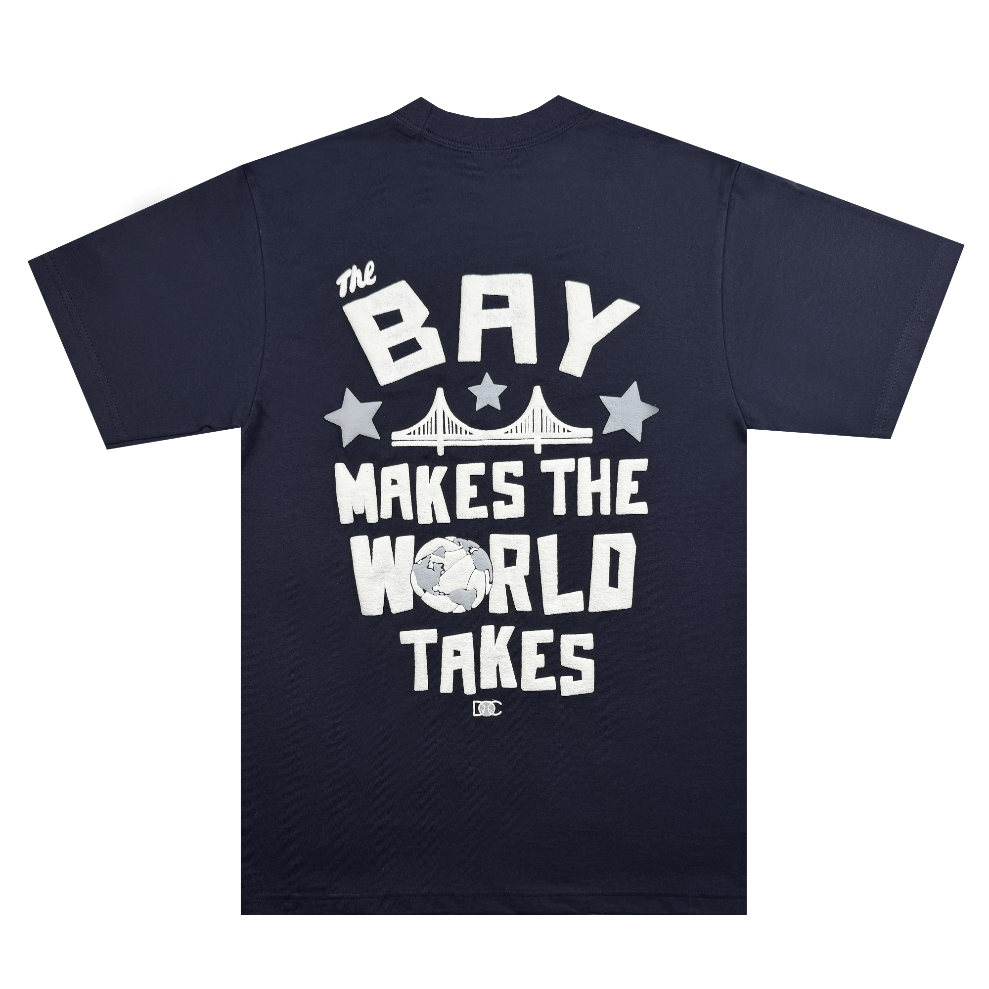 The Bay Bridge Tee by DOC from Oaklandish features a navy blue T-shirt with bold white text, "The Bay Makes The World Takes," encircling a bridge, stars, and globe, merging urban and global culture to highlight the Bay Area's worldwide artistic influence.