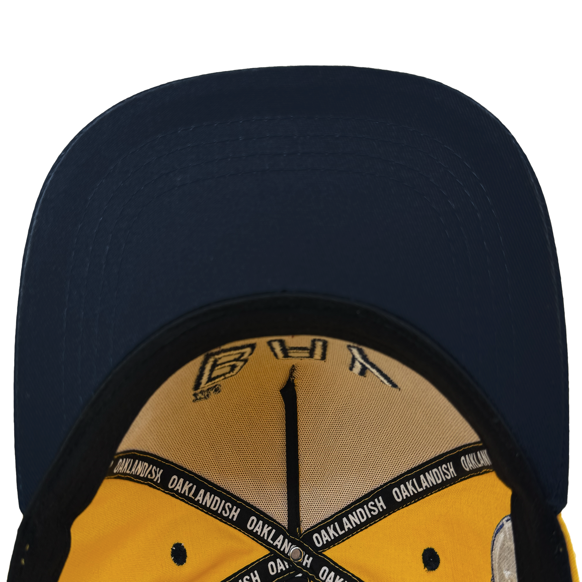 The Bay Bridge Snapback by DOC for Oaklandish has a navy blue brim, yellow lining, and a black sweatband with "OAKLANDISH" in white. It features Bay Area art with a yellow crown underside decorated with intricate black details and stitching.