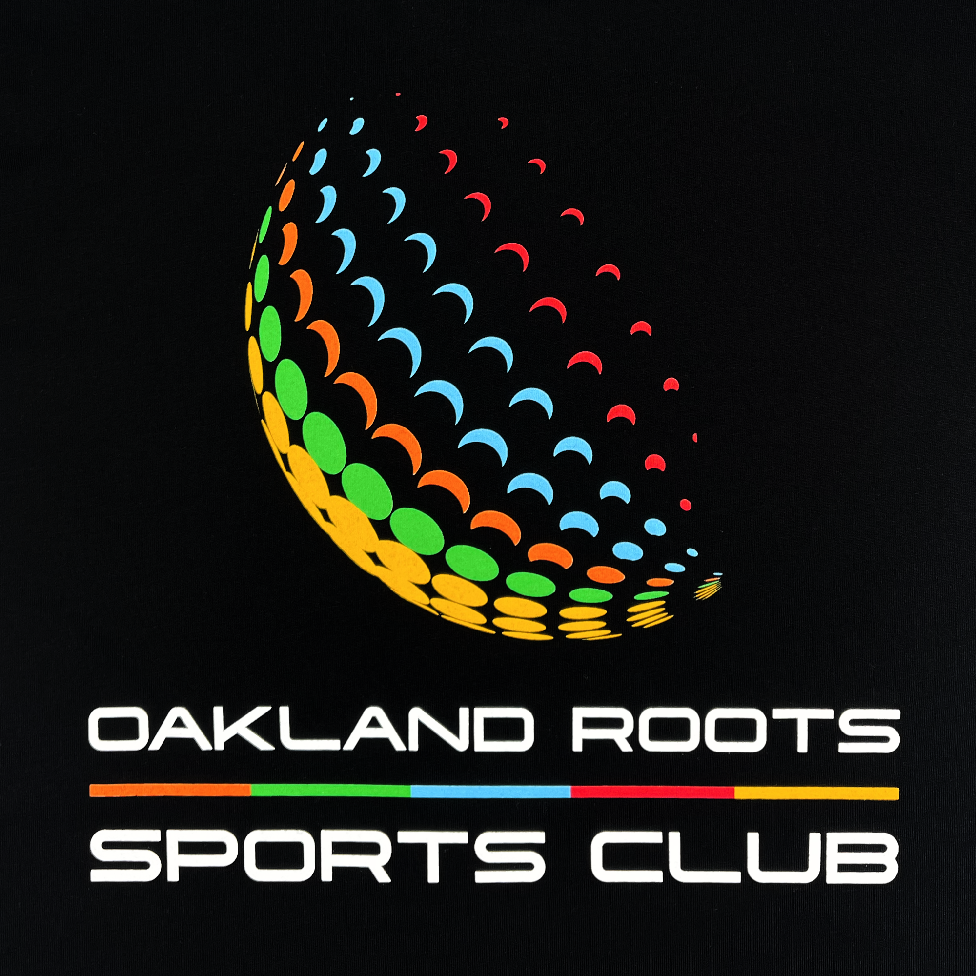 The Foundations Golf Tee from Oakland Roots SC showcases the club's logo with a distinctive half-circle pattern adorned with vibrant dots in green, yellow, orange, red, and blue, mimicking a mosaic. Below this colorful design is the text "Oakland Roots Sports Club" in white along with a thin horizontal line. The design captures the essence of social good and reflects a vibrant community spirit.