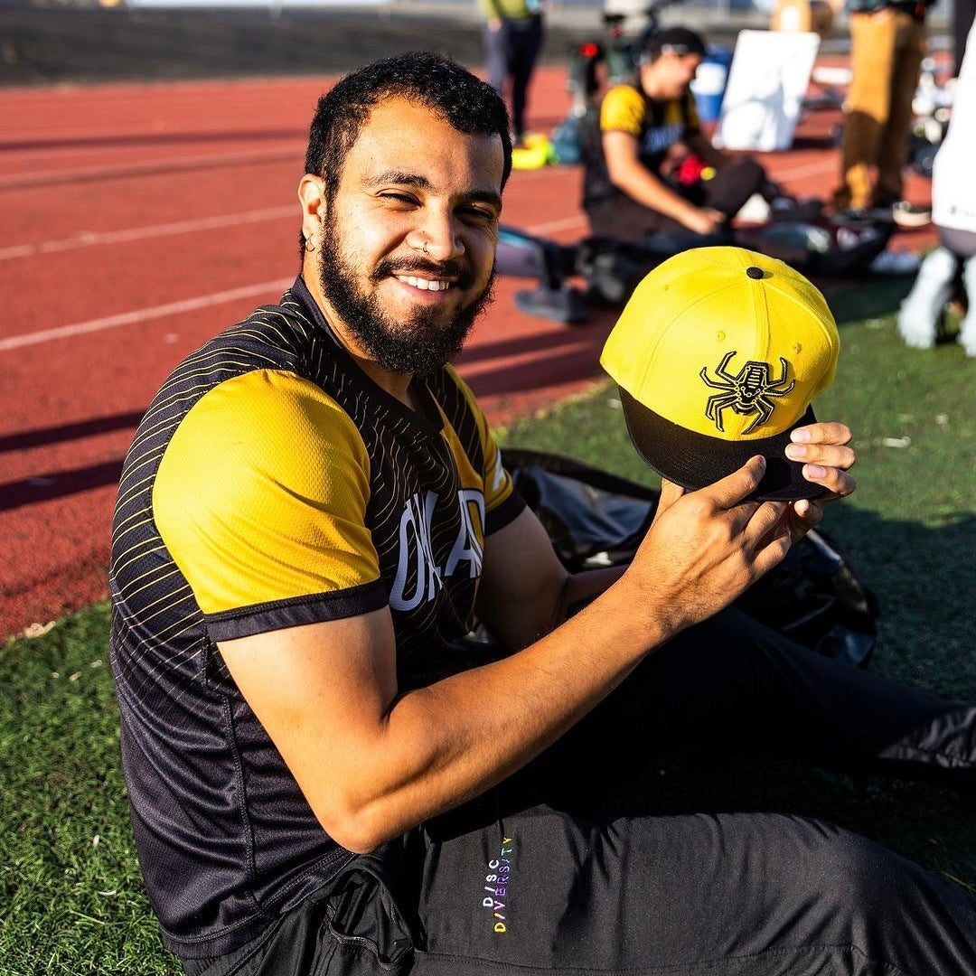 Payer on the field in uniform holding up the hat.