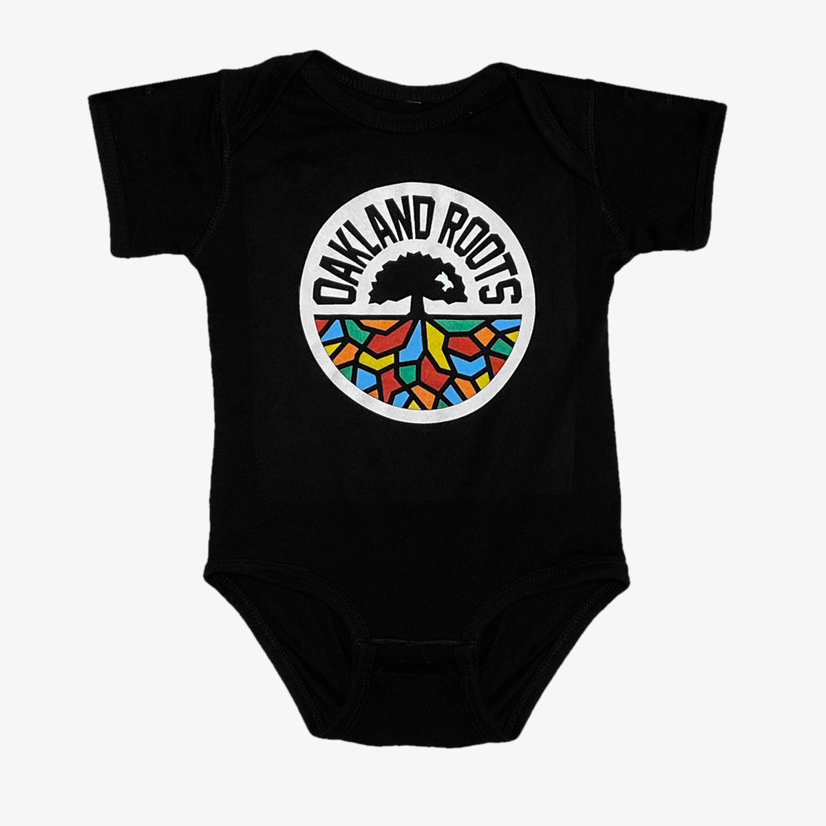 A black Infant Oakland Roots SC Logo One-Piece from Oakland Roots SC, showcasing the club's emblem. This emblem has a white circular background with "OAKLAND ROOTS" in bold, black, capitalized text curved at the top. Inside the circle is a striking black tree, its roots intricately colored in blue, red, yellow, green, and orange—celebrating this vibrant sports club.