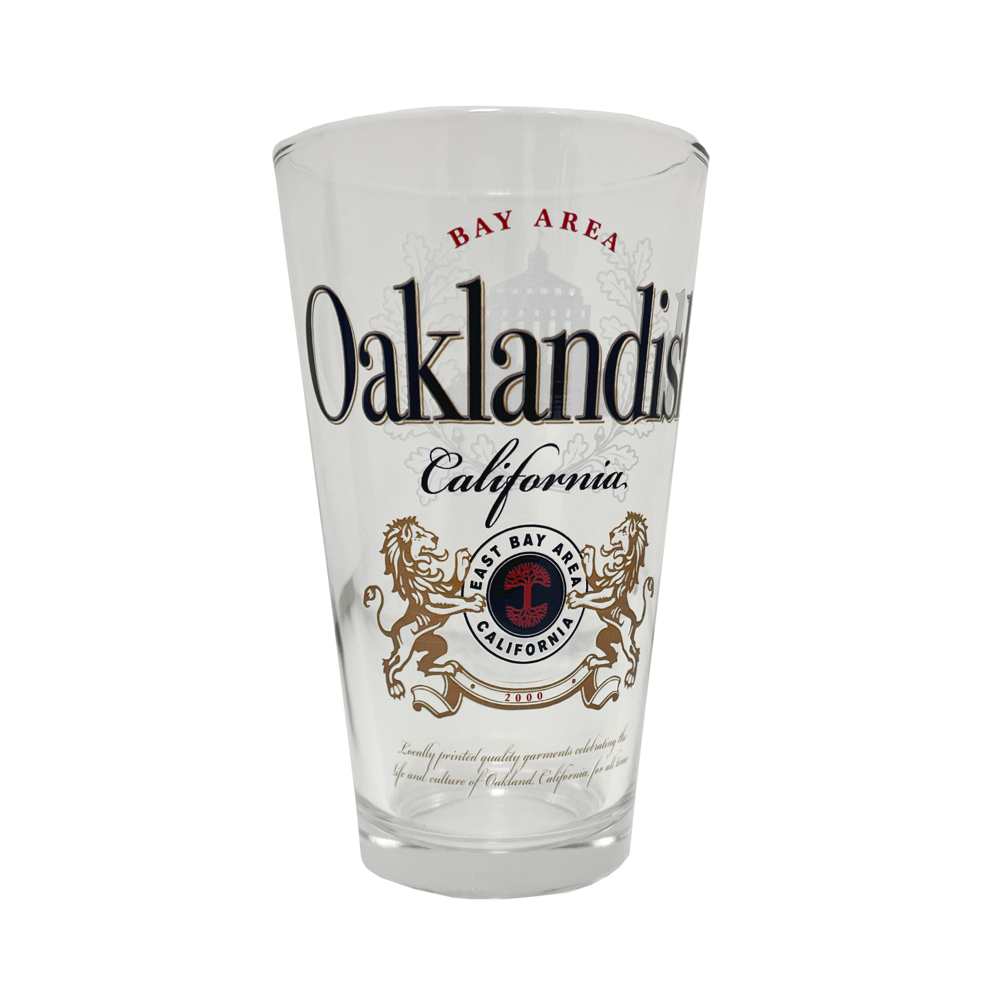 The Lager Pint Glass by Oaklandish is a 16 oz pint glass featuring the text "Bay Area Oaklandish California" in black and red. Below this, intricate graphics depict two lions standing on their hind legs, flanking a red and black emblem that reads "East Bay" and "California." Additional small text appears beneath the emblem, making it perfect for any drinkware collection.