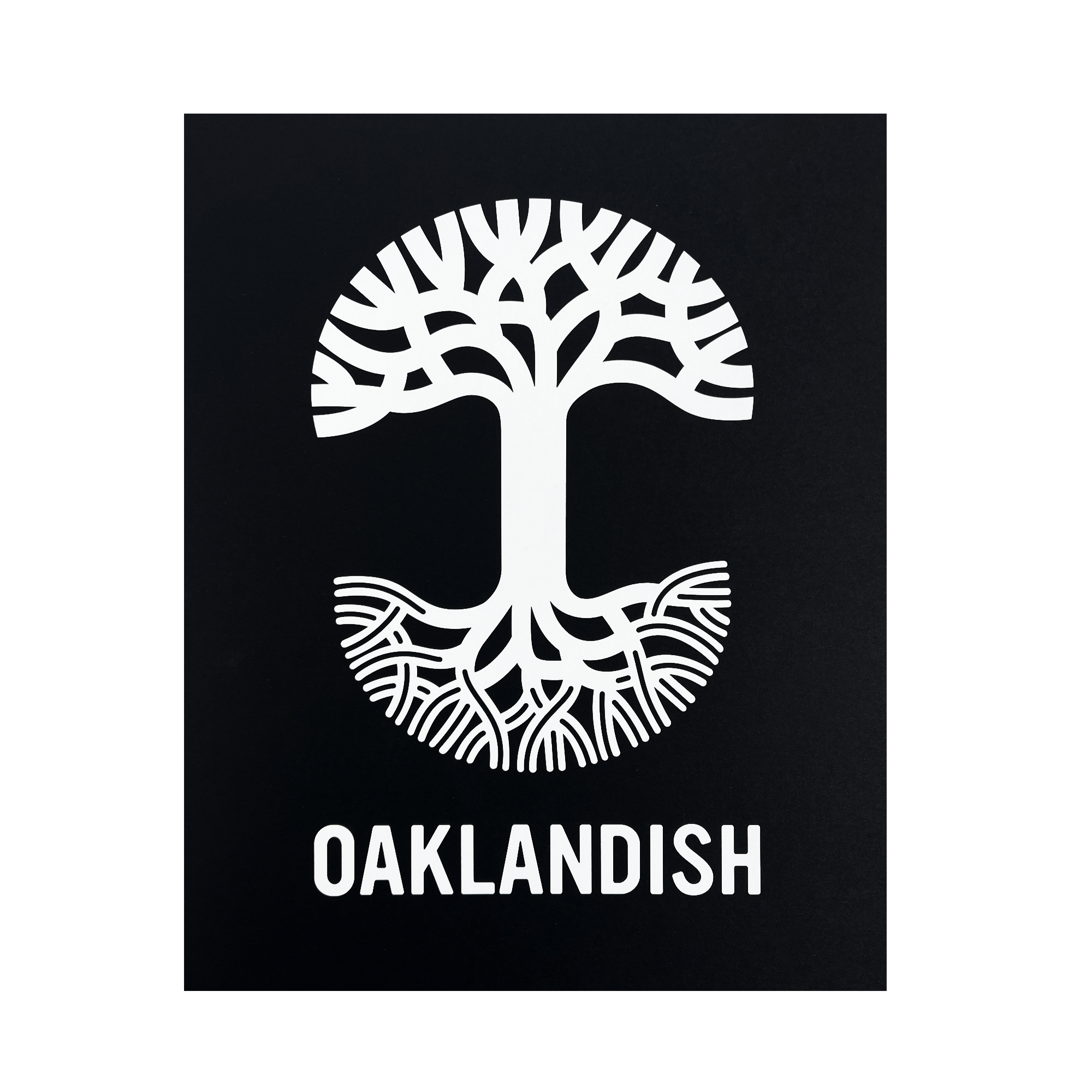 A black background showcases a striking white graphic of a tree creatively designed to resemble the letter "T," with the top half depicting branches and the bottom half depicting roots. Below this symbolic tree, "OAKLANDISH" is prominently featured in uppercase letters on a silver foil cardstock print, known as the Oaklandish New Logo Print by Never Elsewhere.