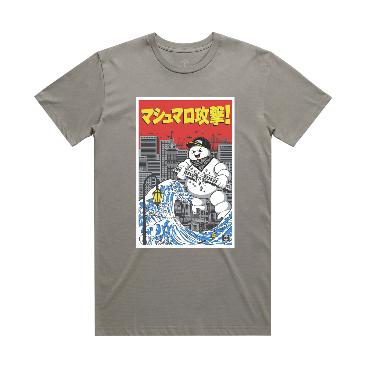 The Oaklandish Marshmallow Tee is a granite classic fit t-shirt featuring a graphic of a marshmallow mascot in a bandana and cap over a city skyline, with a stylized blue wave and red Japanese text reading “Marshmallow Attack!” at the top.