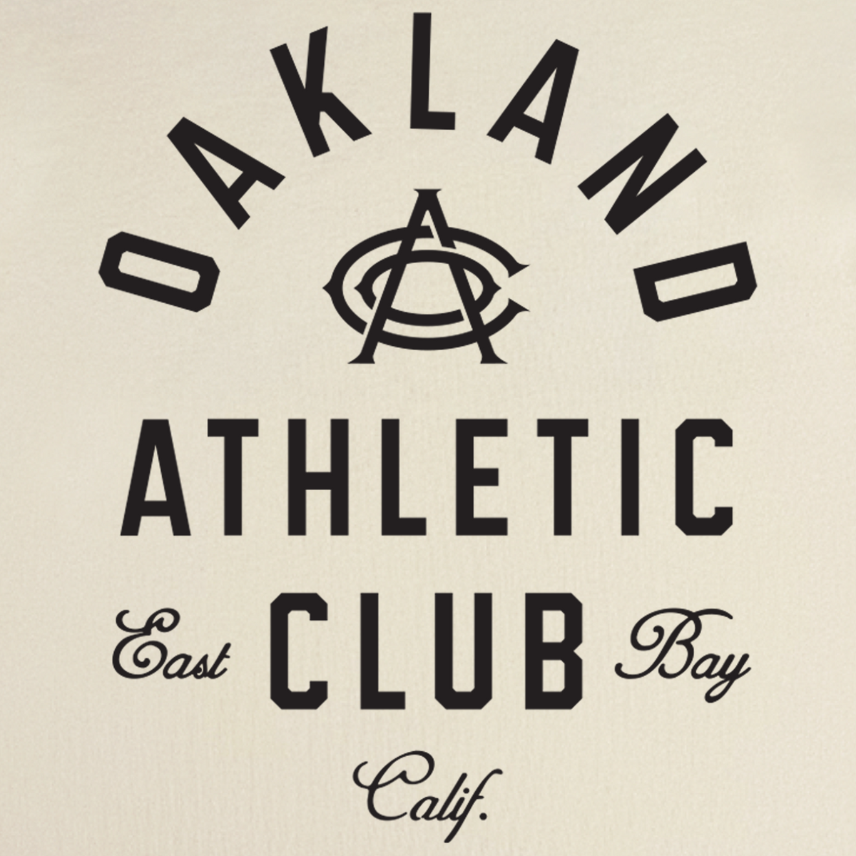 The OAC Tee by OAC features black lettering reading “OAKLAND ATHLETIC CLUB” with a stylized “A” in the center, “East Bay” in script flanking “CLUB,” and “Calif.” in script at the bottom, all printed on a classic fit, heavy-weight cotton t-shirt with a light background.