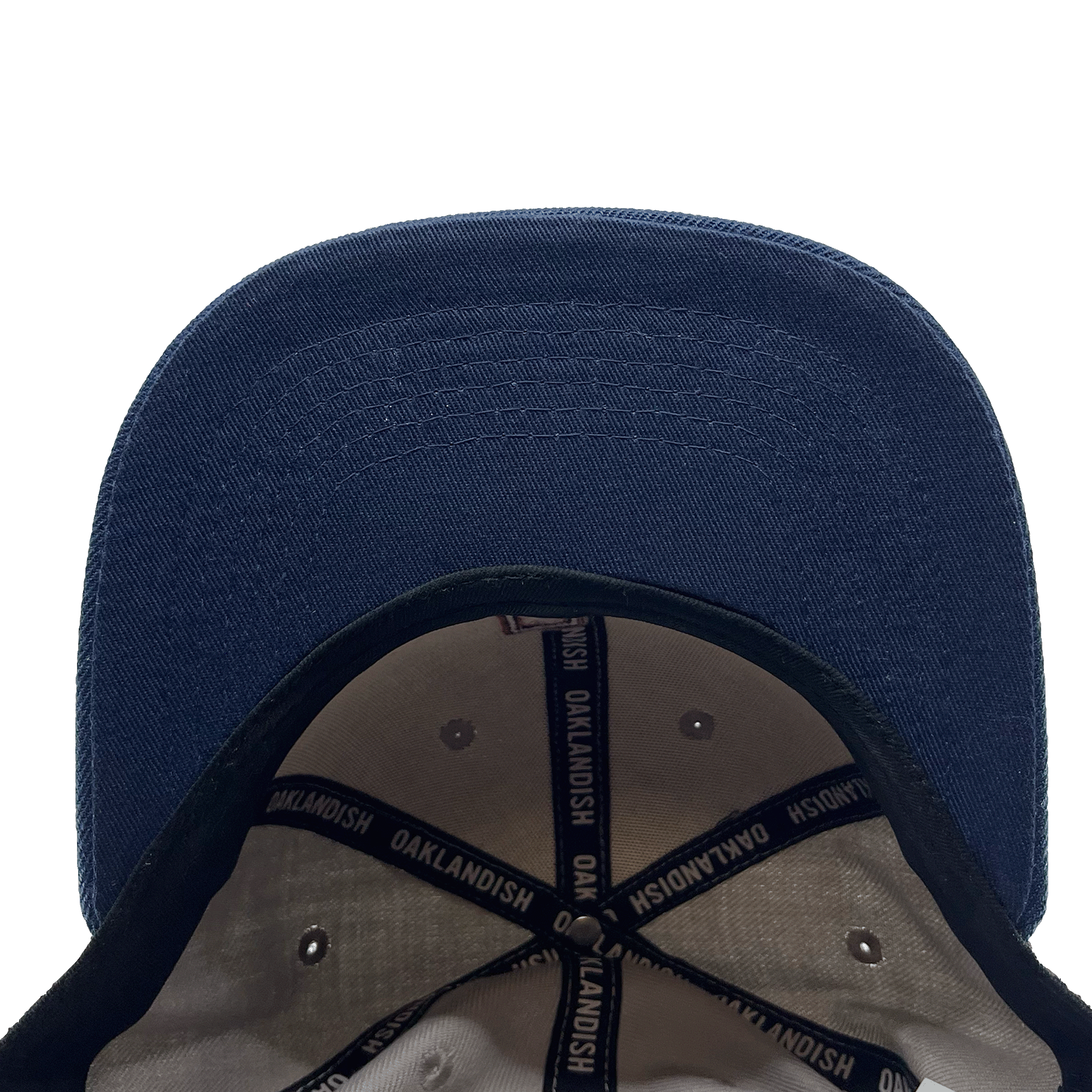 The OAK Monogram Snapback from Oaklandish is viewed from above, showcasing the brim and interior. The inside features white fabric with black edges and adjustable straps. The straps are printed with the word "Oaklandish" in white text on a blue background. This clean snapback hat also boasts an embroidered OAK logo on the front.