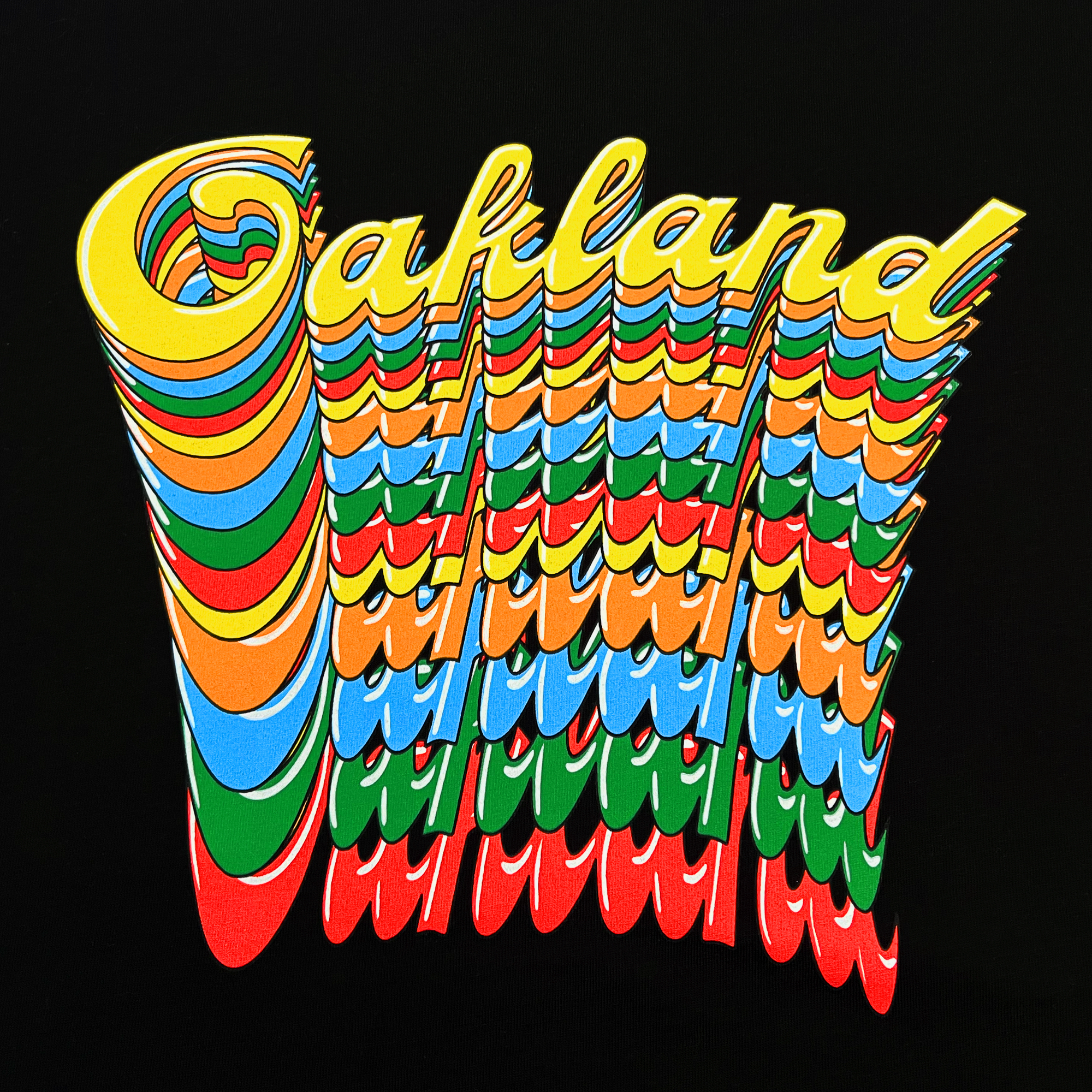 The image showcases the word "Oakland," styled in 3D, wavy, and multicolored text against a black backdrop. The letters cascade downward in vibrant shades reminiscent of the Oakland Roots SC Funk Tee by Oakland Roots SC, featuring colors like yellow, red, green, and blue for a dynamic and visually striking effect.