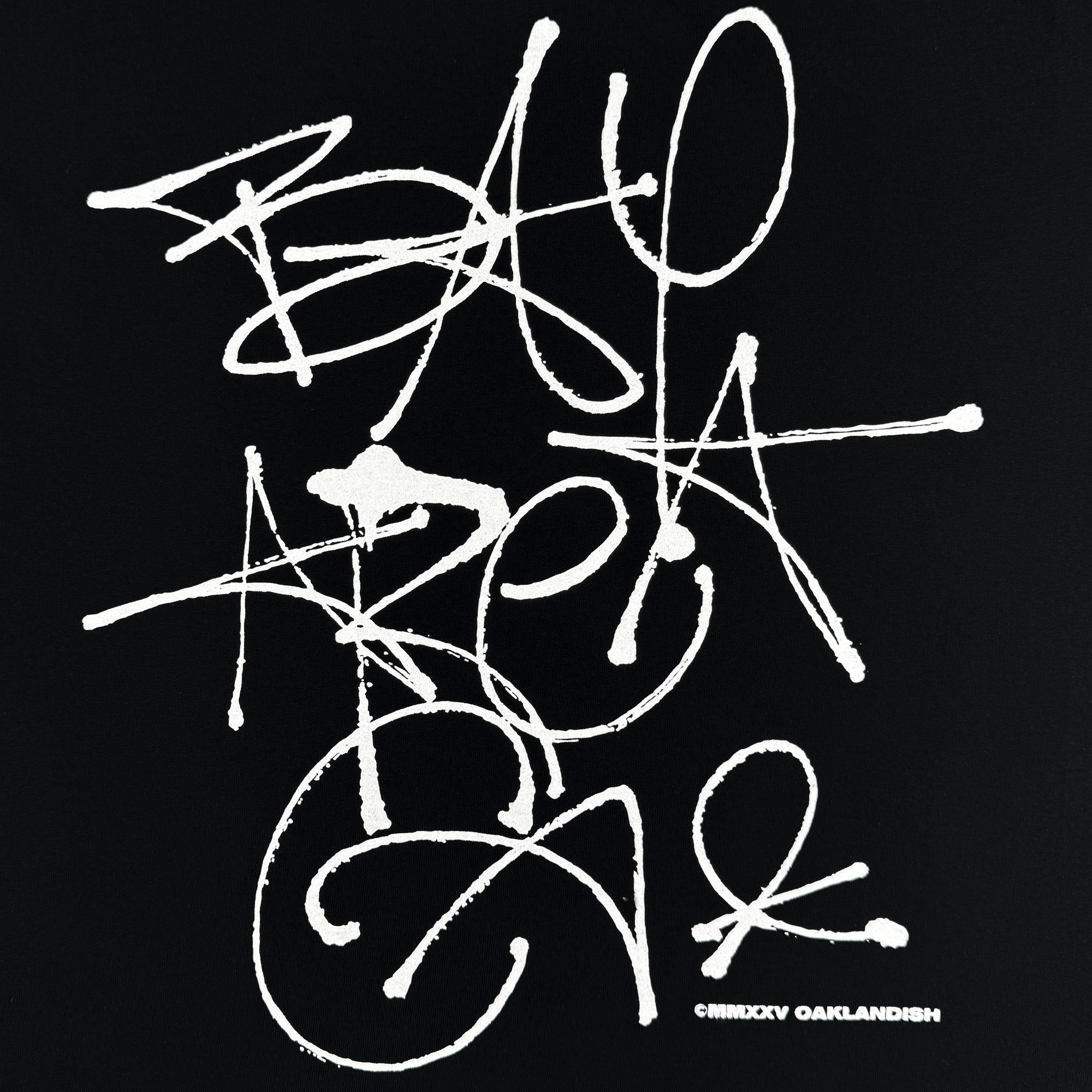 The Oaklandish Presto Tee features white graffiti-style “BAY AREA CAL” text on black, with scribbled, splattered street art vibes. Part of the men’s collection, this classic-fit heavyweight cotton tee has a “© MIDXY OAKLANDISH” at the bottom right.