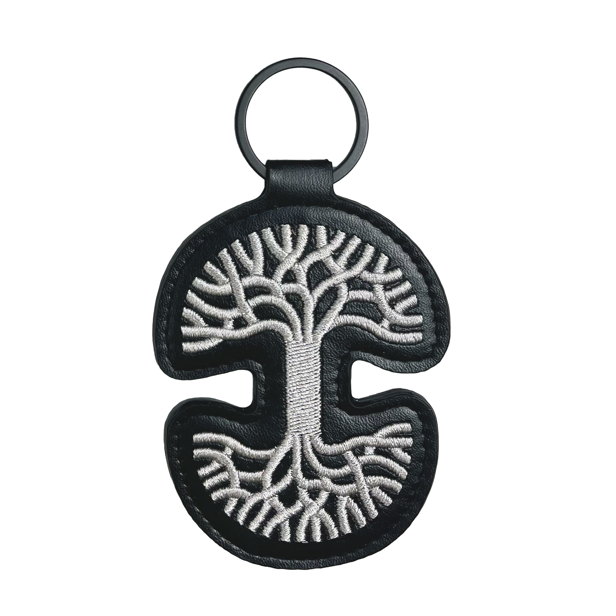 The Oaklandish Logo Keychain by Oaklandish is a stylish black PU leather accessory, showcasing a silver embroidered tree with roots and branches elegantly spreading from the center. It features a curvy, symmetrical design and includes a circular metal ring at the top.