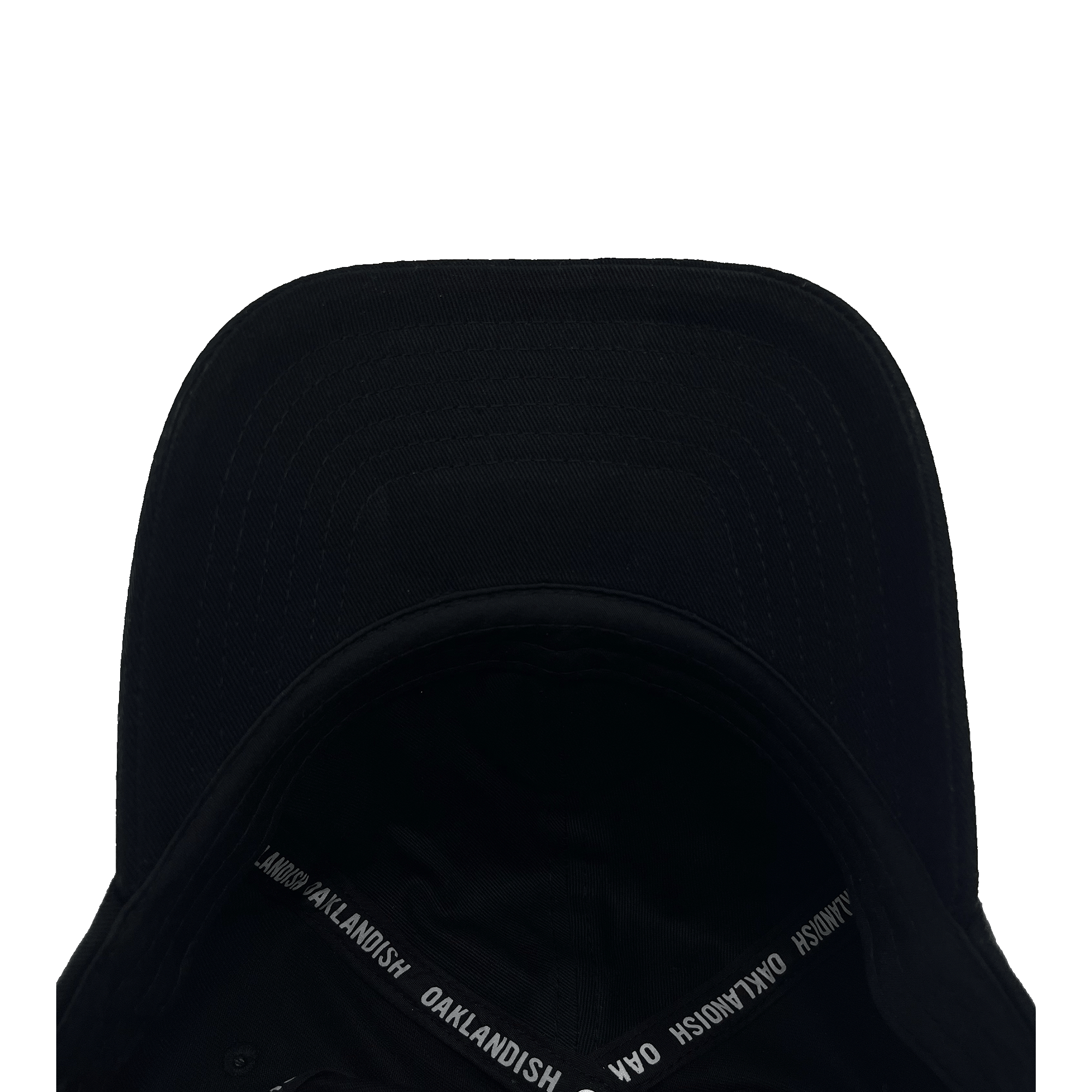 An Oakland Roots SC Logo Curved Visor Hat in black is displayed upside down, unveiling its interior. The inner rim is lined with the text “OAKLANDISH.COM” printed repeatedly in white. The visor's underside features noticeable stitch lines, and the exterior remains free of any logos or additional markings, capturing the essence of the Oakland Roots sports club.