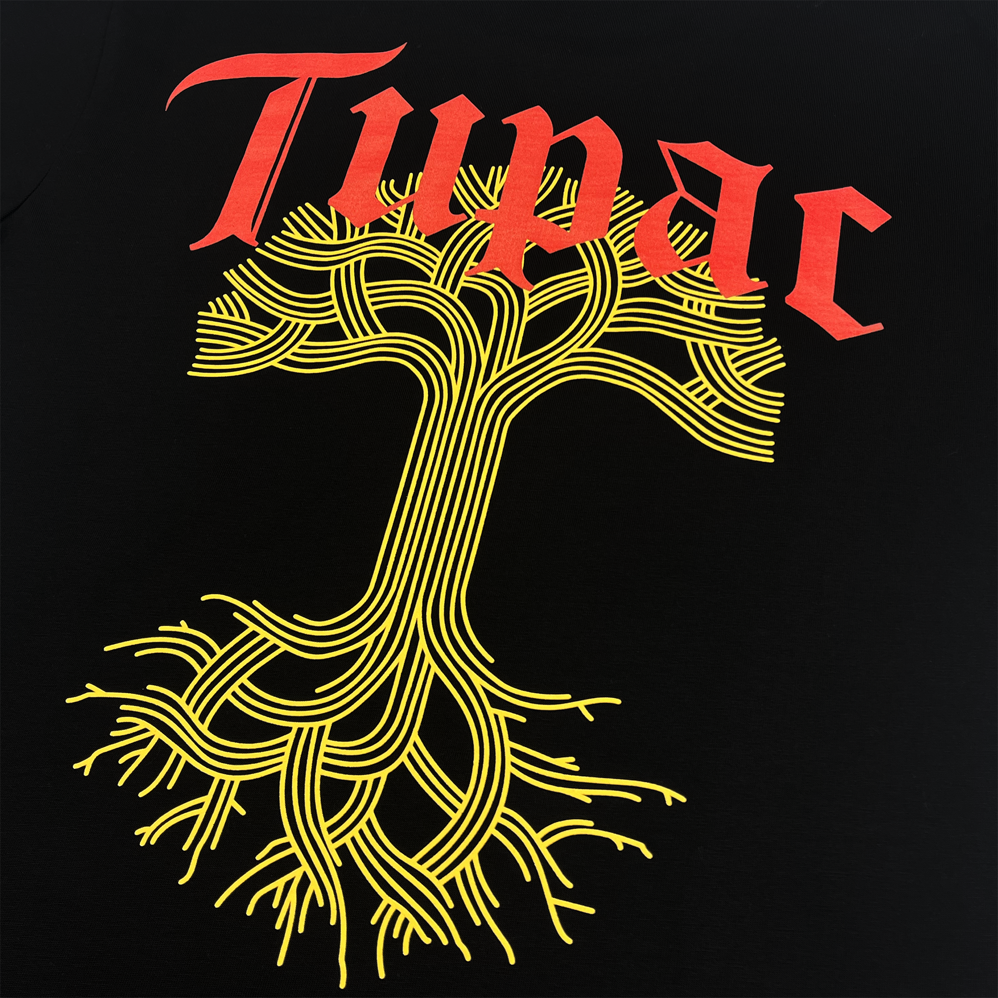 The Roses Tee by Oaklandish features a stylized yellow tree with intricate, intertwining branches and roots on a black background. Above the tree, "Tupac" is displayed in bold red, medieval-style font, creating a striking visual effect against the contrasting dark backdrop.