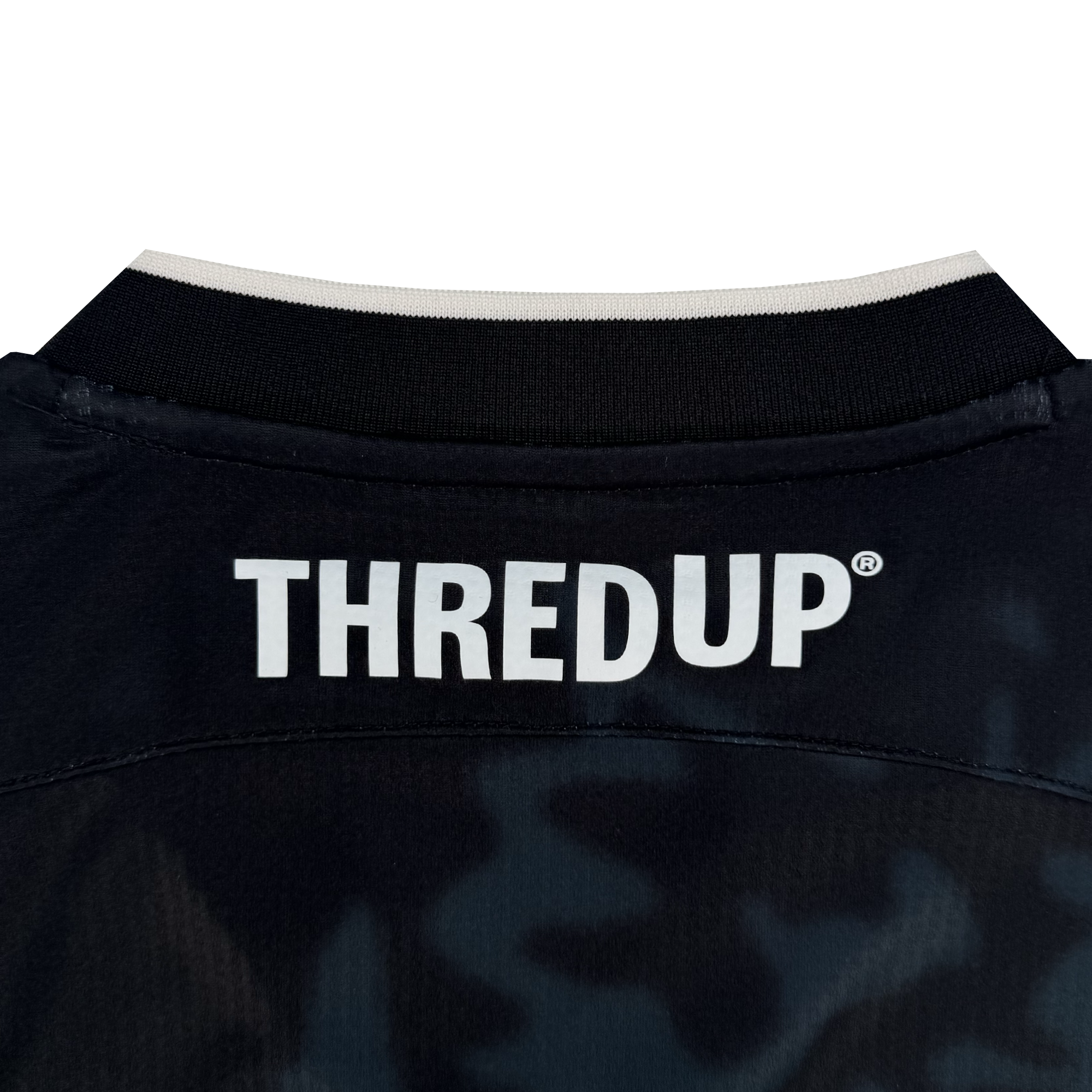 Close-up of the back collar area of a dark Oakland Soul Unisex Soul Bloom Kit jersey with a black and white collar. "THREDUP" in bold white letters is printed across the upper back. The fabric has a subtle camo pattern, inspired by Oakland.