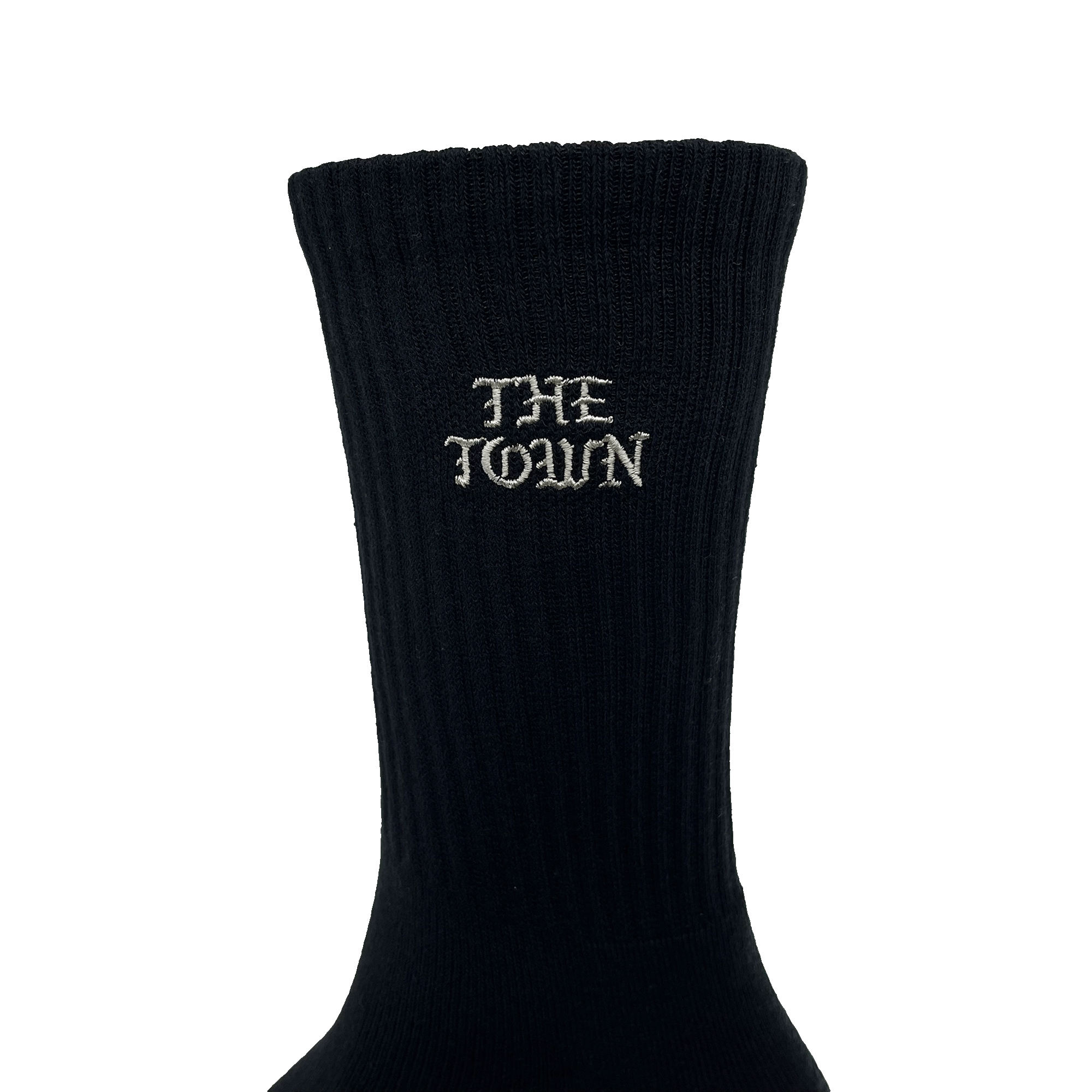 A black crew sock from Oaklandish, displayed against a plain green background with the words "THE TOWN" embroidered in white near the top in old English lettering. The sock has a ribbed texture that runs vertically from the ankle to the upper band. Known as "The Town Old English Sock," this one size fits most stylish piece is perfect for any wardrobe.