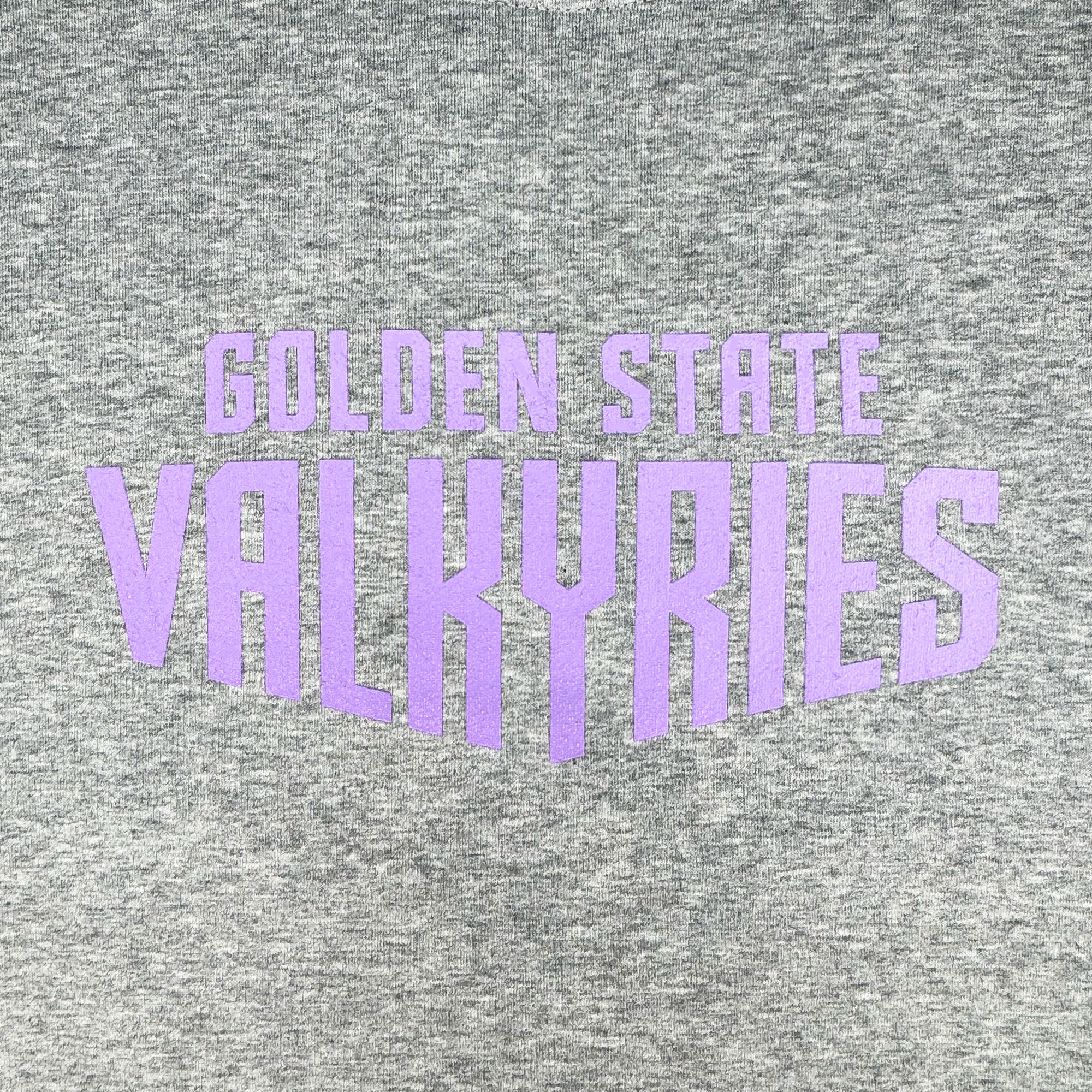 A close-up of the GSV Golden State Valkyries Circle Lock Up Crew, a premium heavyweight gray fleece sweatshirt with bold purple “GOLDEN STATE VALKYRIES” text in a large, stylized geometric design.
