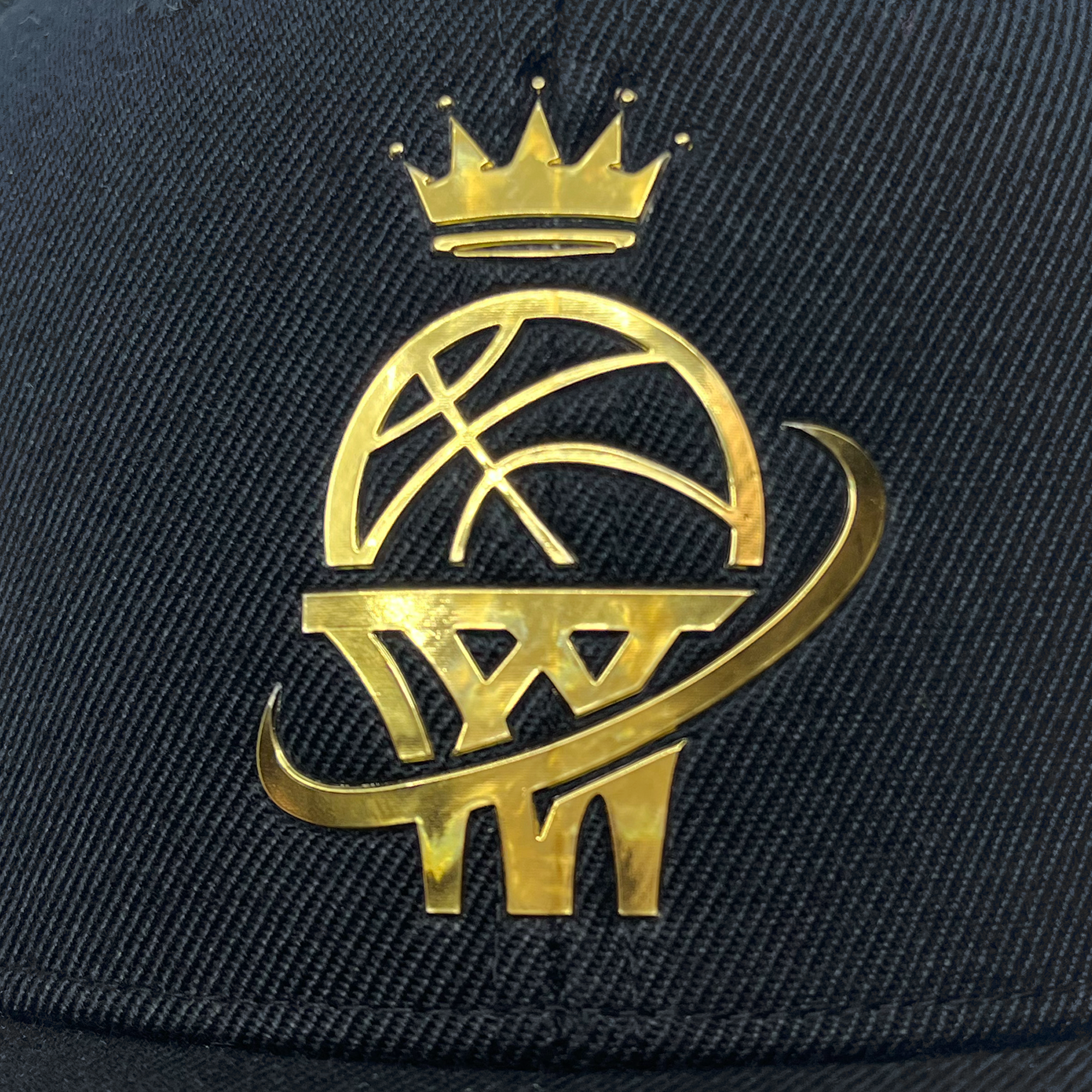 Detailed front view of a black snapback hat with gold WPBA logo on the front crown.