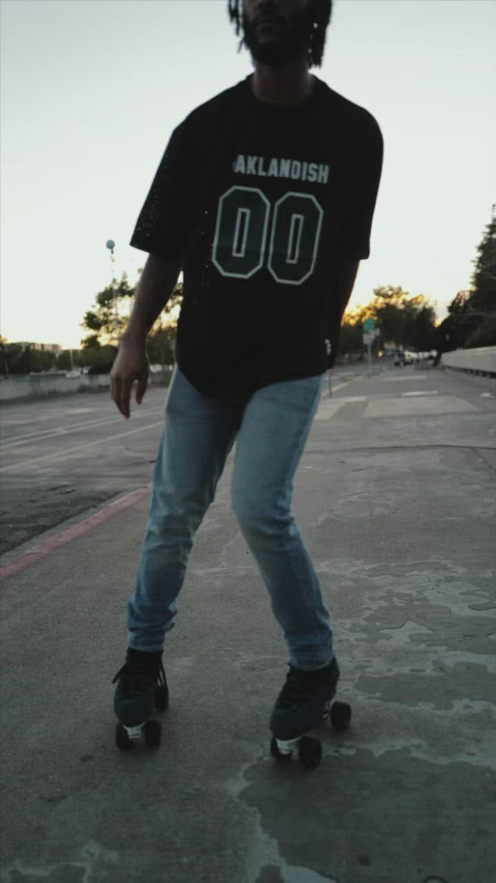 Woman and man playing outside in a mesh Oaklandish football jerseys.