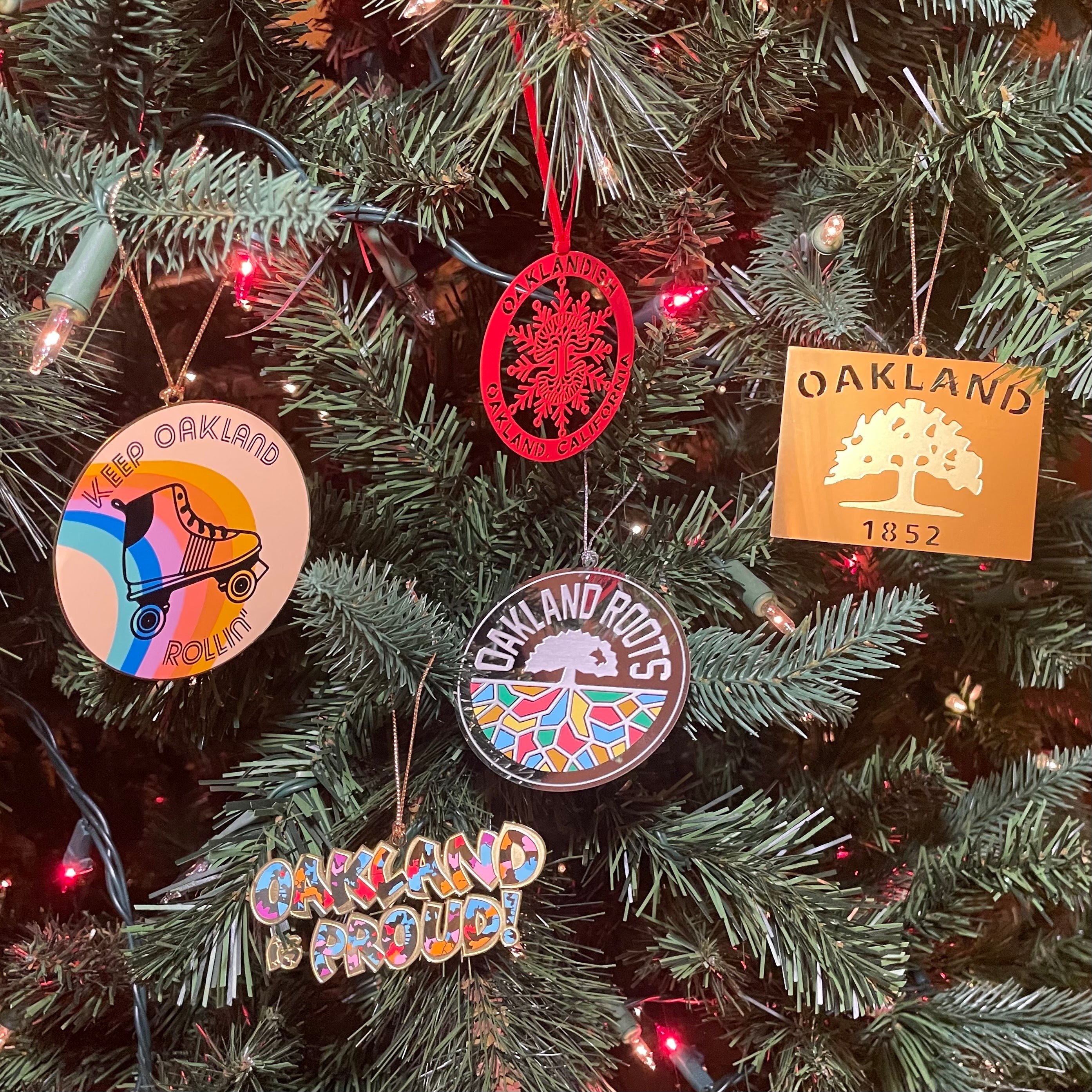 Assortment of holiday tree ornaments from Oaklandish hanging on a decorated on tree.