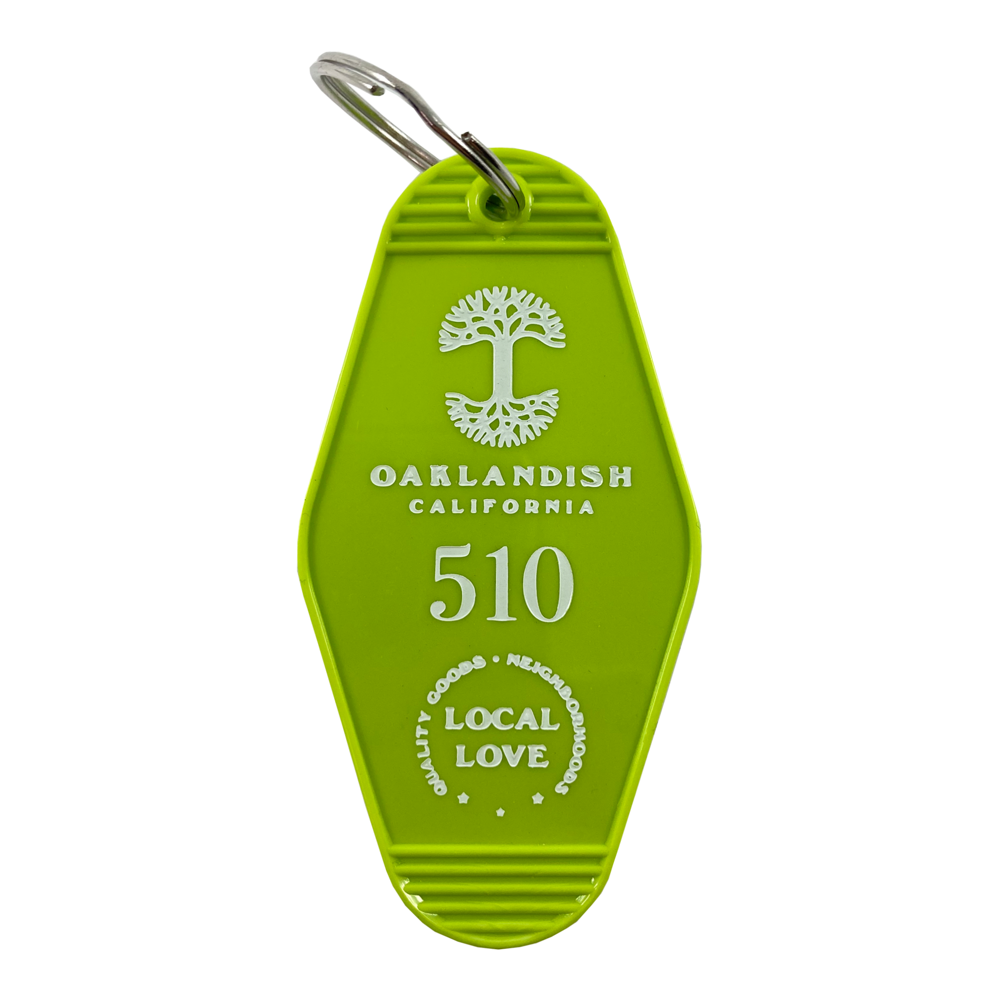 The Local Love Key Tag by Oaklandish is a green, hexagonal keychain that mirrors a vintage motel key tag. It showcases a white emblem of a tree above the inscription "Oaklandish California," with the number "510" prominently displayed below. At the bottom, the words "Quality Goods, Neighborhood, Local Love" are elegantly arranged in a circular pattern.