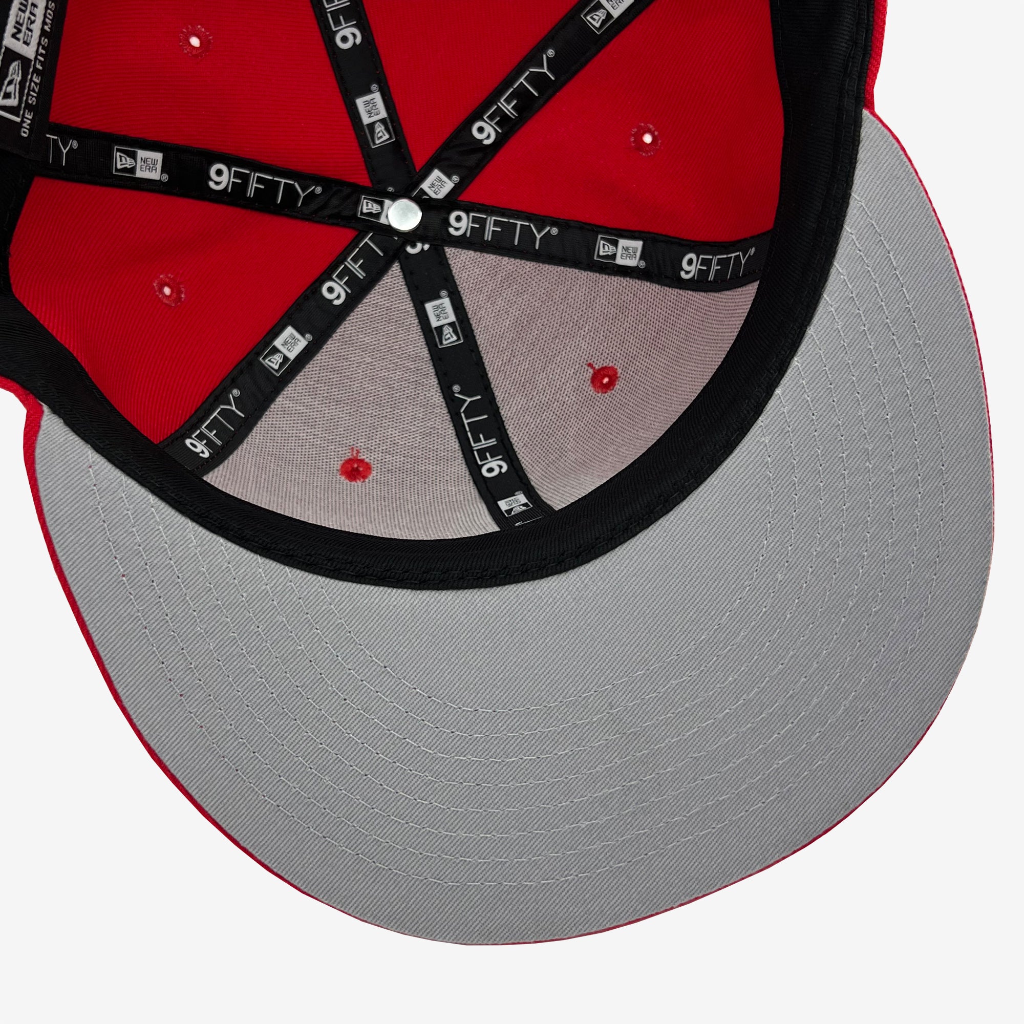 Top view of the inside of an Oaklandish New Era Official 9FIFTY Snapback in red and black. The hat features black fabric strips with white "9FIFTY" branding, a grey under-visor, and a red sweatband. The central button is white, and there are red eyelets on each panel for ventilation.