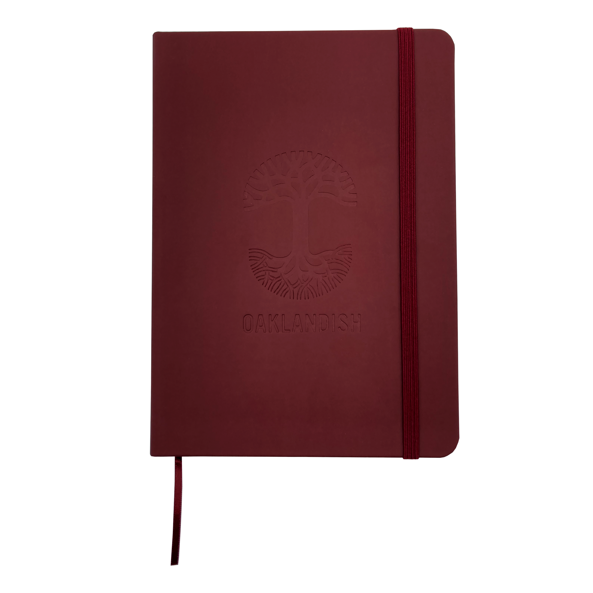 The Oaklandish Emblem Journal is a red 80-page lined notebook with a matching elastic band and ribbon bookmark. It features a debossed Oaklandish tree logo above the word "OAKLANDISH" on the PVC cover. The journal has rounded edges and a clean, minimalist design.