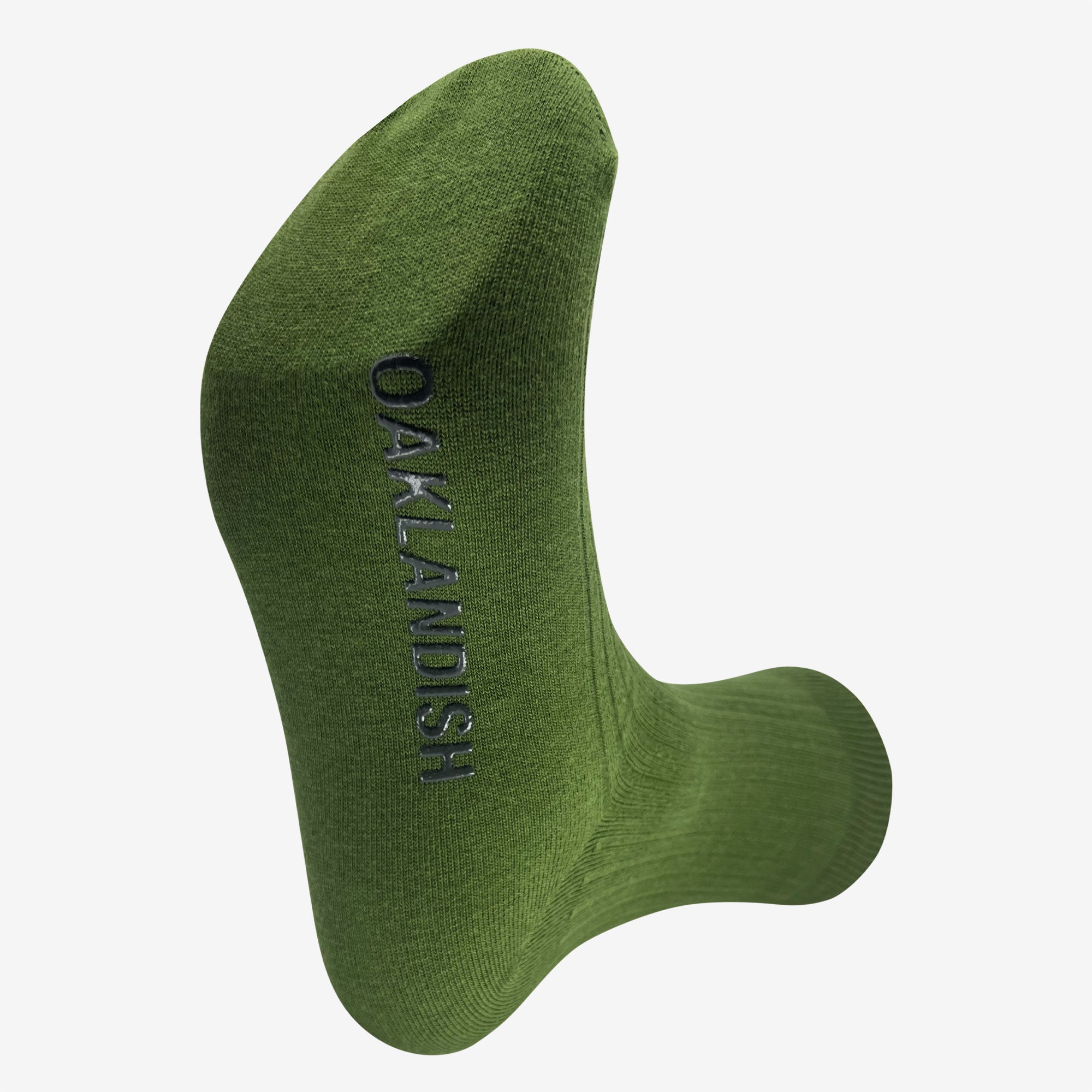 A Grip Crew Sock from Oaklandish in green, featuring the word "OAKLANDISH" woven in black thread running vertically along the side. This "one size fits most" sock is displayed clearly against a light gray background to showcase the text.